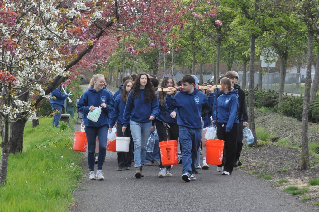 Sequim Gazette photo by Matthew Nash/ Sequim High School Interact Club members start their journey from Sequim Middle School to the Dungeness River to fill buckets and containers to symbolize how far some people in the world must travel for water.