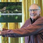 Don Berger, the only member with college rowing experience when the Sequim Bay Yacht Club established a rowing program 10 years ago, poses with a picture of himself at the clubs 50th anniversary dinner.
