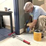 Sequim Gazette photo by Matthew Nash/
Tyler Conkle with Sequim Valley Foursquare works with fellow volunteers during Sequim Beautiful Day to paint and replace fiber reinforced polymer (FRP) wall panels and cove base by the bathrooms inside the Sequim Boys & Girls Club.