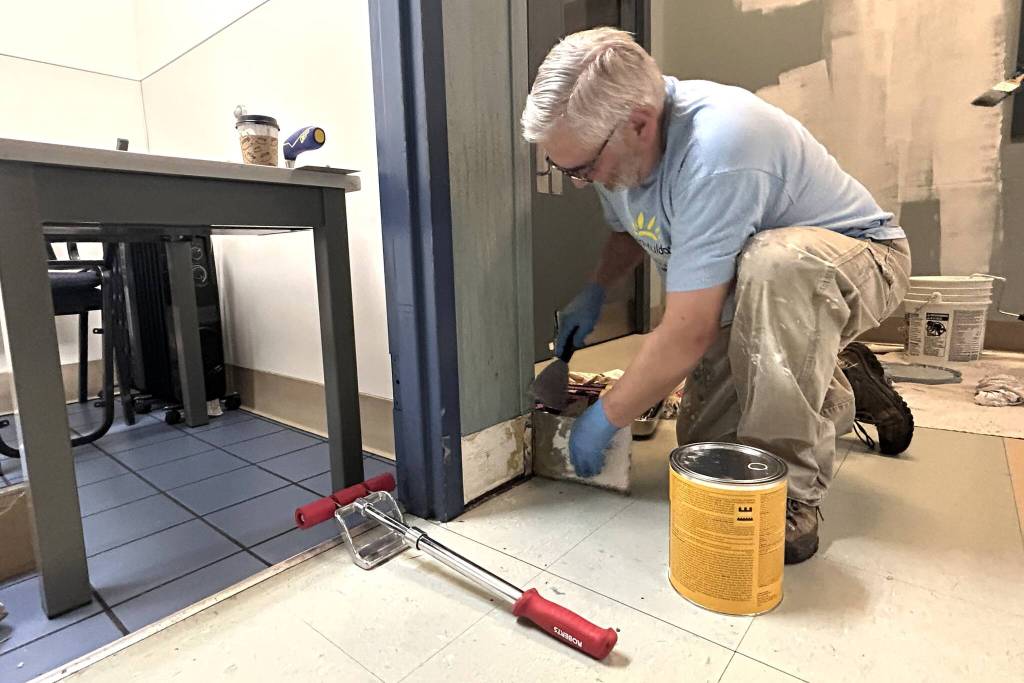 Sequim Gazette photo by Matthew Nash/
Tyler Conkle with Sequim Valley Foursquare works with fellow volunteers during Sequim Beautiful Day to paint and replace fiber reinforced polymer (FRP) wall panels and cove base by the bathrooms inside the Sequim Boys & Girls Club.