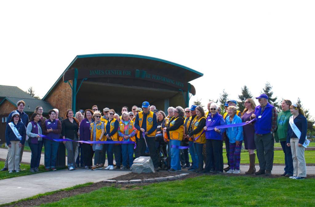 Brian Pulk, president of the Sequim Valley Lions Club, cuts a ribbon to celebrate a paved pathway around the James Center for the Performing Arts. The Lions paid about $50,000 for the project.