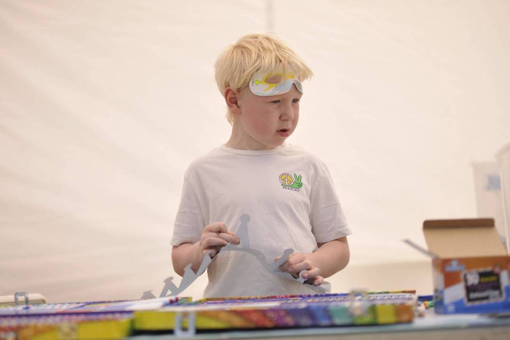 Sequim Gazette photo by Matthew Nash/ Sawyer Coburn, 6, makes a crown in the Sequim Irrigation Festivals activity booth. It was his first time attending and his family plans to make a return trip.