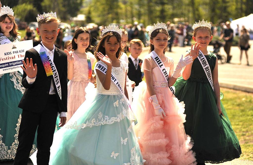 Sequim Gazette photo by Matthew Nash/ Sequim Irrigation Festival junior royalty and button design winners march in the Kids Parade on Saturday.