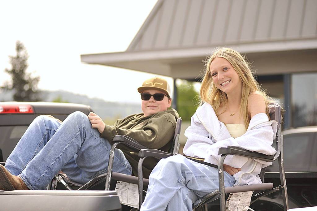 Sequim Gazette photo by Matthew Nash/ Cousins Wyatt Carpenter, 15, and Sydney Owens, 17, wait for the Grand Parade to march by as they watch from a truck bed. They attend the parade with their family every year, and they come from a Sequim pioneer family, with their grandfather Milton Lynch honored as a Grand Pioneer in 2018 and his granddaughter Shelby Wells a royalty princess in 2019.
