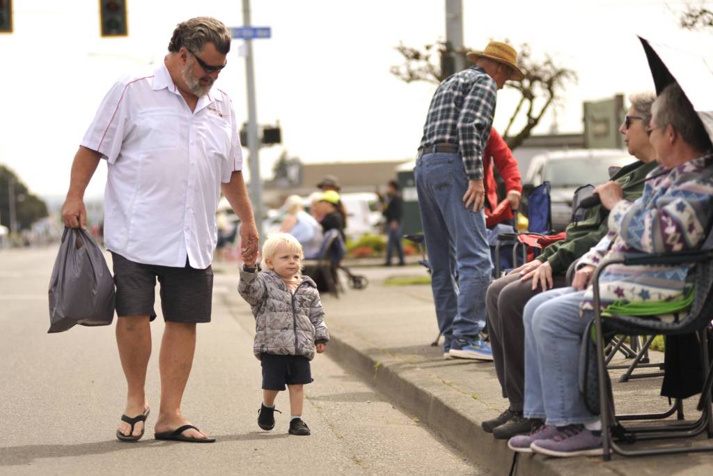 Sequim Gazette photo by Matthew Nash/ Mike Schrock of Sequim walks with his two-year-old grandson Grayson prior to the start of the Grand Parade. It was Graysons first Grand Parade, Schrock said.