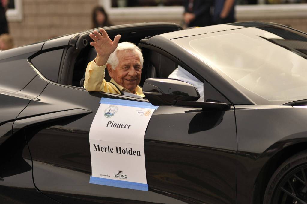 Sequim Gazette photos by Matthew Nash 
Honored Pioneer Merle Holden waves to audience members of the Grand Parade. He was one of four pioneers honored this year, including Beverly McInnes, Lou Pinnell, and Lyle Brown.