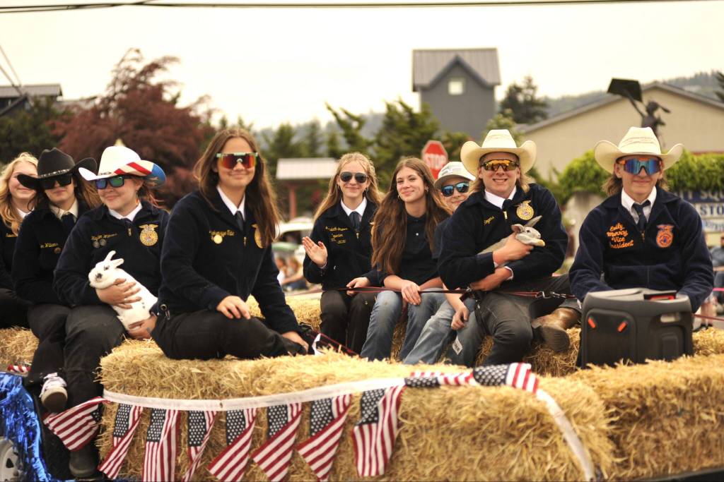 Sequim Gazette photo by Matthew Nash/ Sequim FFA members ride in a trailer for the Grand Parade while holding a few bunnies theyve raised.