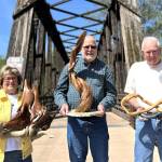 Sequim Gazette photo by Matthew Nash 
Olympic Driftwood Sculptors, from left, Tuttie Peetz, Rick Hill, and Marc McBride stand with their pieces by the Railroad Bridge that will be on display at the clubs Driftwood Art Show May 16-17 in the Dungeness River Nature Center.