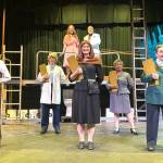 Sequim Gazette photo by Matthew Nash/ Actors with Urinetown the Musical rehearse the song Mr. Cladwell. They include, from front left, Charlie Medlong (as McQueen), Nikki Forrest (Dr. Billeaux), Rebecca Maberry (Ms. Millennium), Fey Beeson (Secretary), Joodie Klinke (Senator Fipp), and, top left, Sunshine Peterson (Hope), and Ron Graham (Caldwell B. Cladwell).
