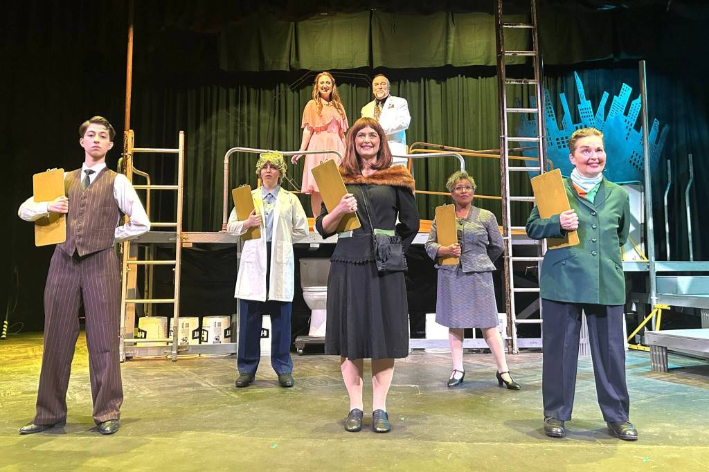 Sequim Gazette photo by Matthew Nash/ Actors with Urinetown the Musical rehearse the song Mr. Cladwell. They include, from front left, Charlie Medlong (as McQueen), Nikki Forrest (Dr. Billeaux), Rebecca Maberry (Ms. Millennium), Fey Beeson (Secretary), Joodie Klinke (Senator Fipp), and, top left, Sunshine Peterson (Hope), and Ron Graham (Caldwell B. Cladwell).