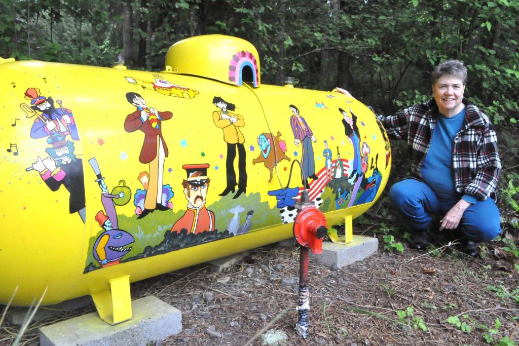Sequim Gazette photo by Matthew Nash
Monika Livingstone of Blyn/Gardiner kneels by her propane tank she spent about a month designing and painting after feeling inspired by The Beatles Yellow Submarine.