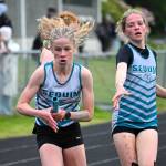 Photos by Liv Thompson 
Eleanor Jones takes the baton from teammate Emme Henrikson during the 4x400 relay on May 19. They along with teammates Lucy Greenwalt and Nathalie Gomez won the event at the league meet and broke SMS previous record going 4:43.87.