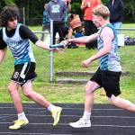 Nolan Oase takes the baton from Braylon Waters during the 4x400 meter relay. They and teammates Carter Fenner, and Will Brooks won first at the league meet running 4:25.87.