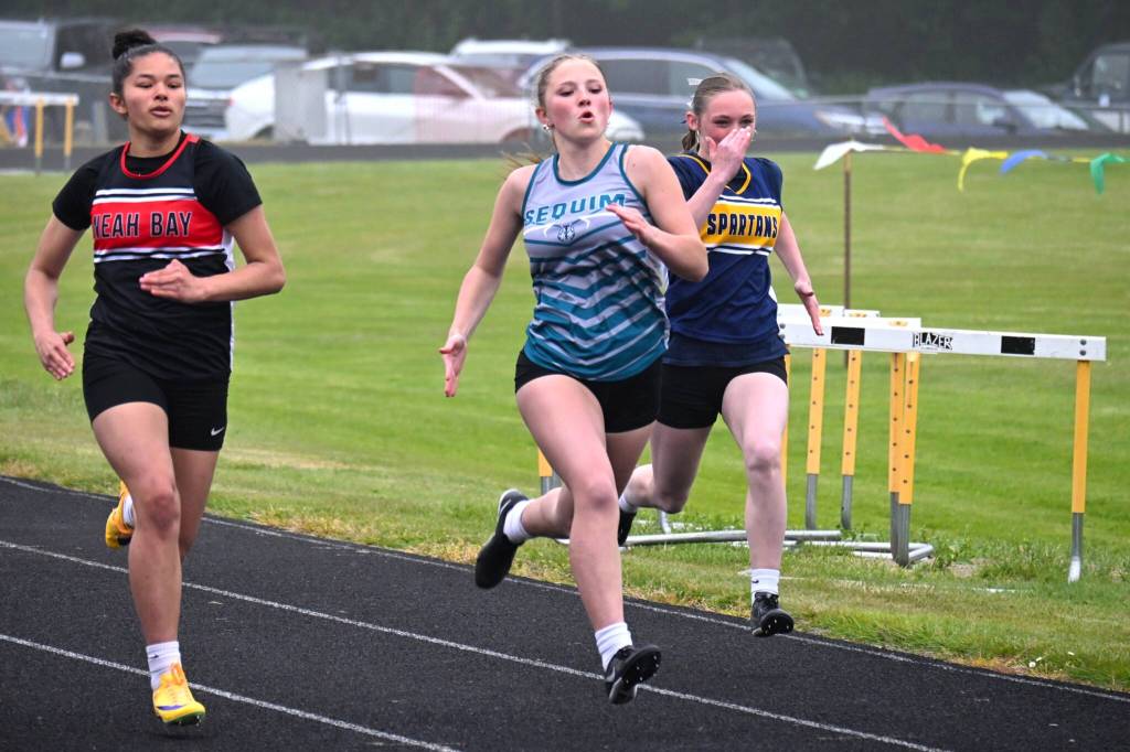 Vaira Luke, center, runs the 100 meters where she ran a personal best (14.77) at the Olympic League meet.