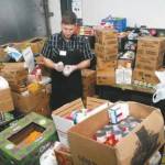Peninsula News Group photo/ In this photo published in the Peninsula Daily News in 2015 or 2016, Perry, then the Port Angeles Food Banks warehouse manager, sorts food donations at the food banks former location at 401 S. Valley St.