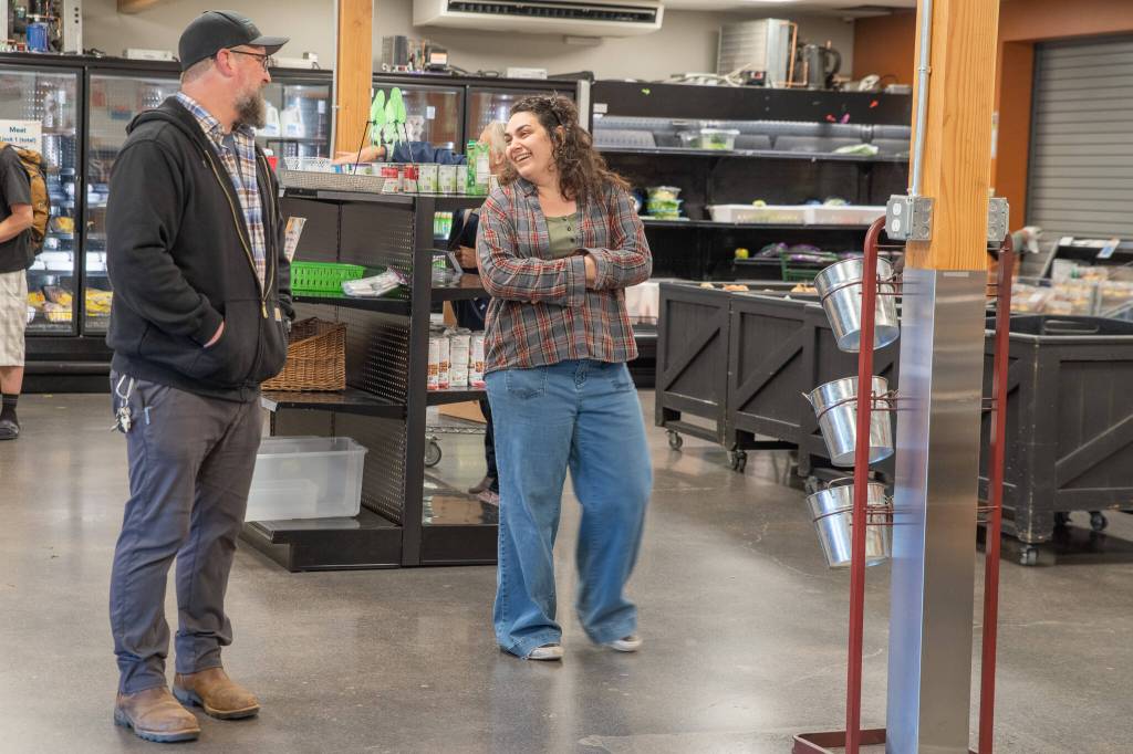 Perry shares a light moment with Market Manager Analise Graziani inside The Market area of the expansive warehouse at 632 N. Oakridge Dr. that was once a Budweiser distribution site.
