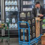 Sequim Gazette photos by Emily Mathiessen
A client shops at The Market at the Port Angeles Food Bank while Operations Manager Kevin Perry stocks the refrigerated cases.
