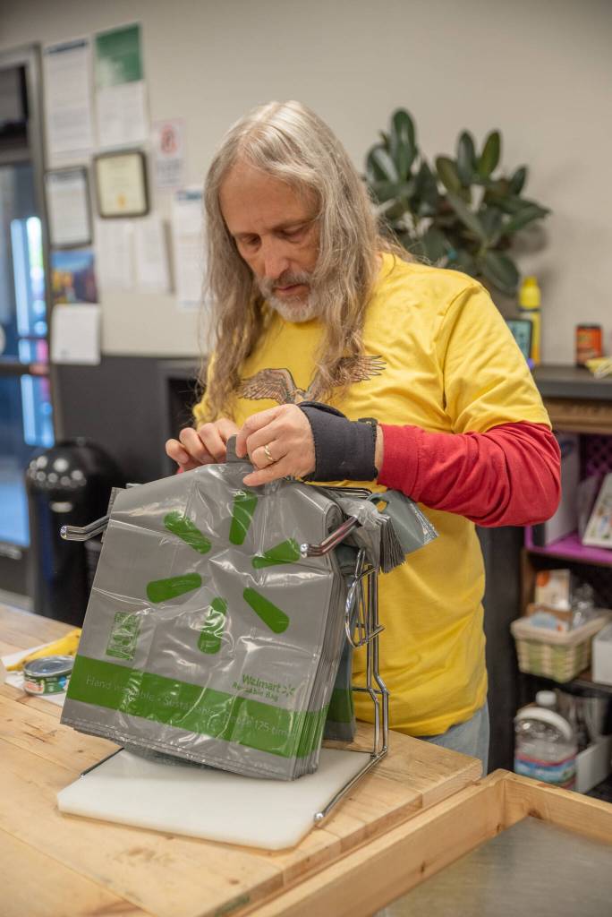 Volunteer Paul Stehr-Green prepares plastic bags for food bank clients.