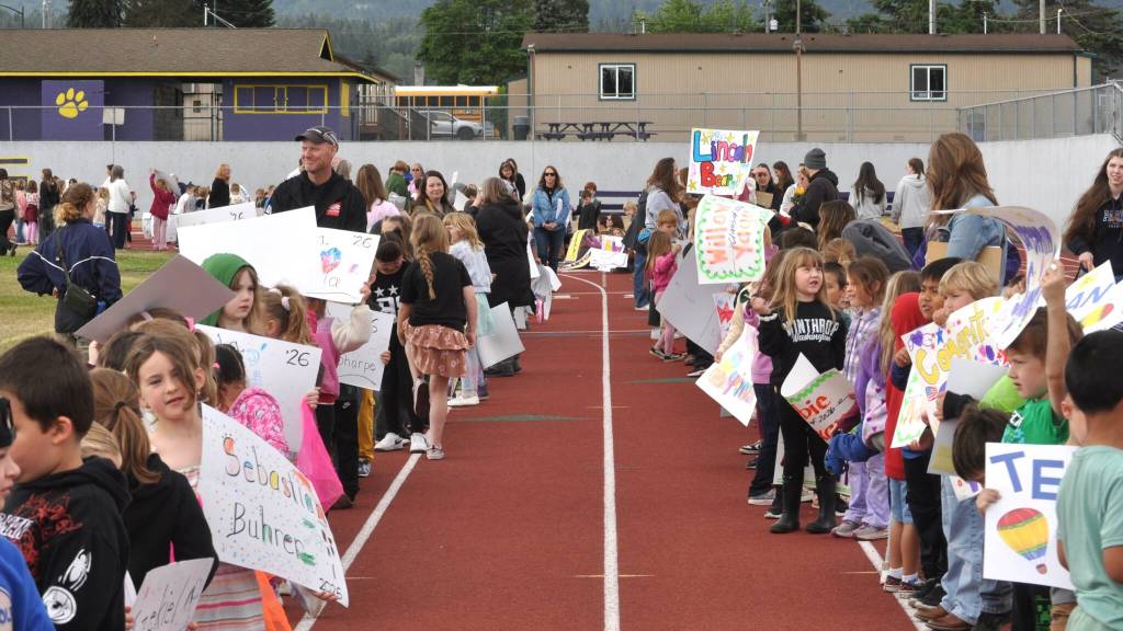 Sequim Gazette photo by Matthew Nash/ Students from Greywolf Elementary hold signs for Sequim High Schools 12th graders before the start of the Grad Walk.