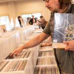 Ryan Smith of Chicago, Illinois browses through albums during his first visit to the Sequim Record Show. He said he liked the variety, and noted that collections included pre-owned items as well as new, with some still wrapped.