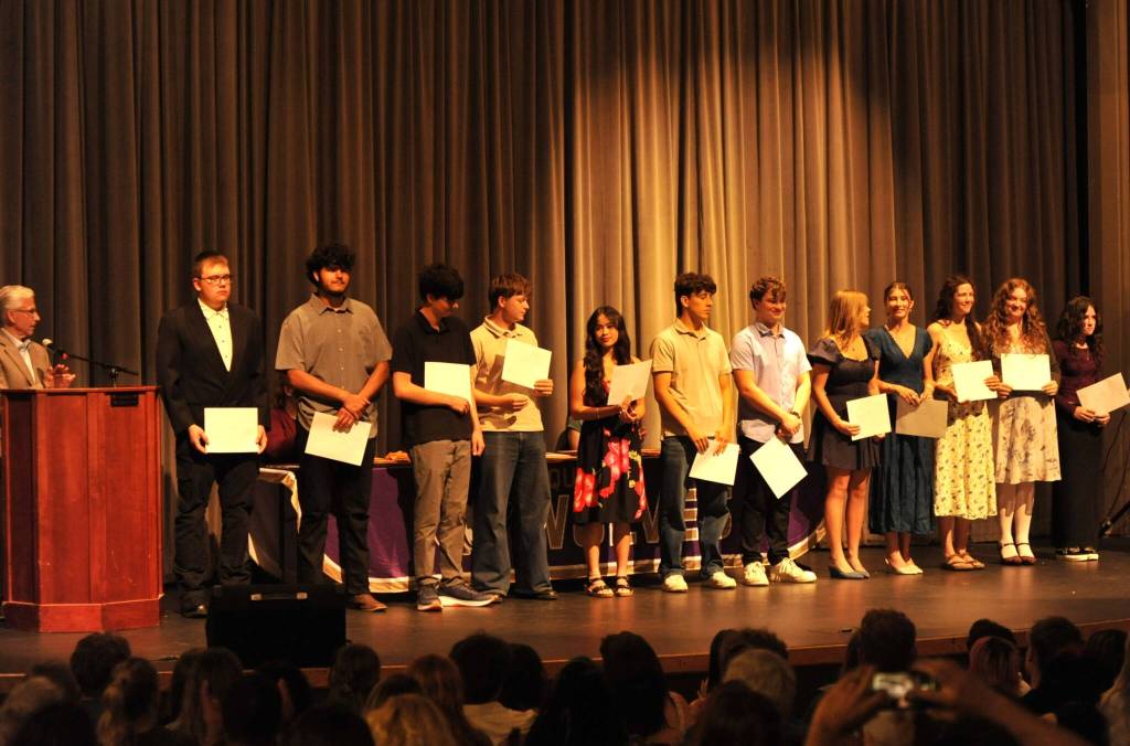 Sequim Gazette photo by Matthew Nash/ Sequim Sunrise Rotary member Eric Lewis, on left, congratulates the clubs multiple scholarship recipients.