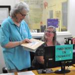 Sequim Gazette photo by Matthew Nash/ Tama Bankston, KSQMs administrative director, talks with volunteer Dee Davenport at the entrance of KSQM.