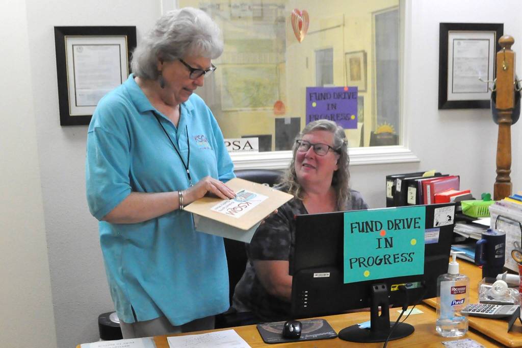 Sequim Gazette photo by Matthew Nash/ Tama Bankston, KSQMs administrative director, talks with volunteer Dee Davenport at the entrance of KSQM.