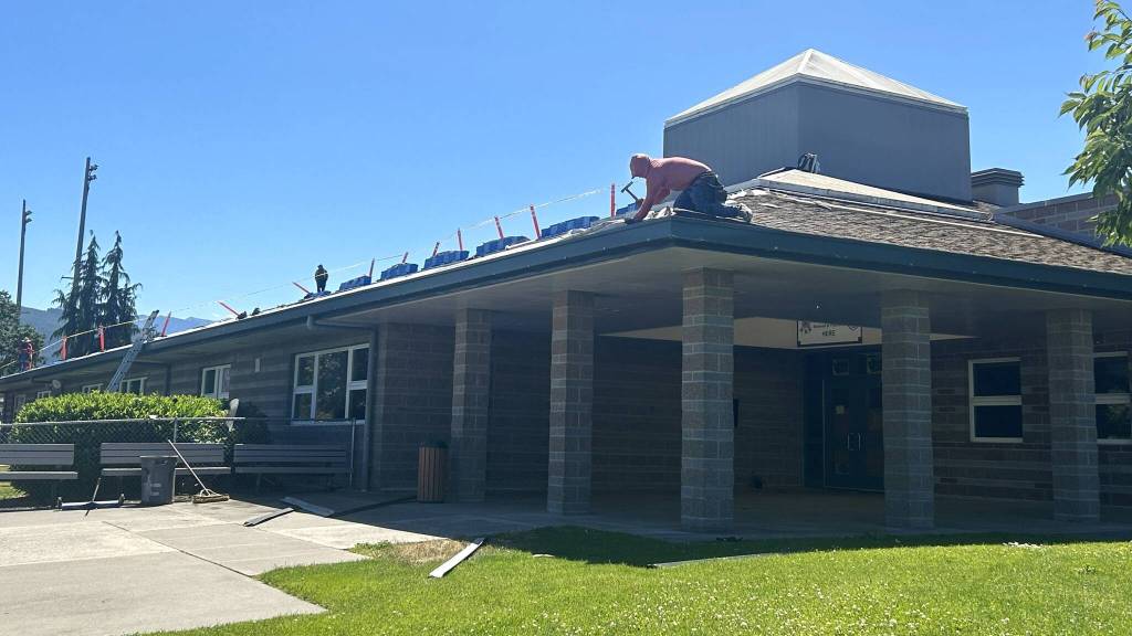 Sequim Gazette photo by Matthew Nash/ Crew members with Safecover Roofing replace the roof at Sequim Middle School on June 17.