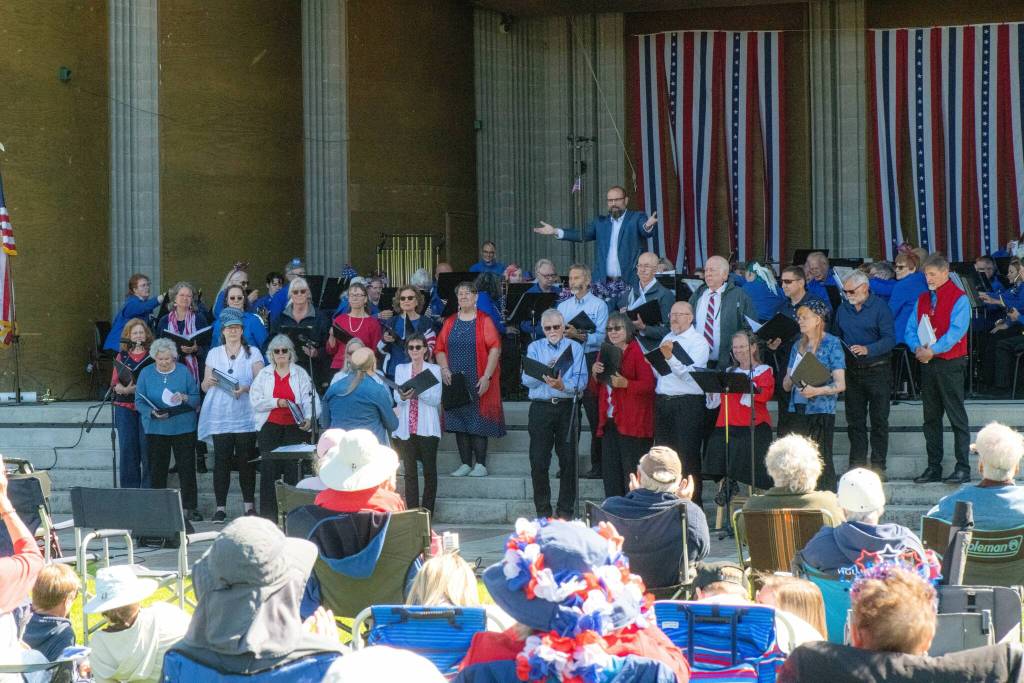 Sequim Gazette photo by Monica Berkseth/ Sequim City Band director Tyler Benedict, top center, recognizes the Peninsula Singers and their director Steve Humphrey during their show Sounds of America.