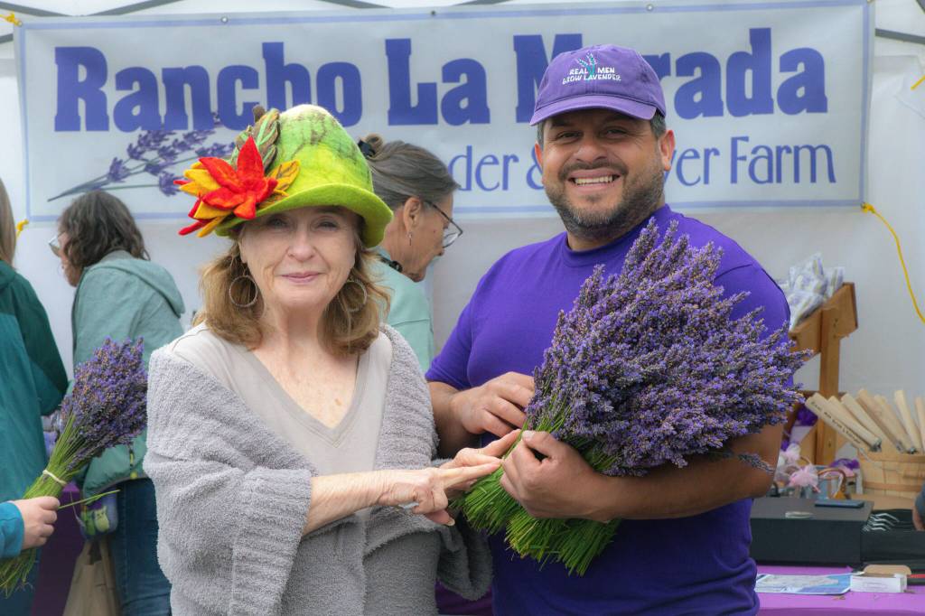Sequim Gazette photo by Monica Berkseth
Sandra Bliss of San Antonio, Texas proudly poses with Juan Gonzalez, owner of Rancho La Morada Lavender Farm, during Sequim Lavender Festival in the Park.