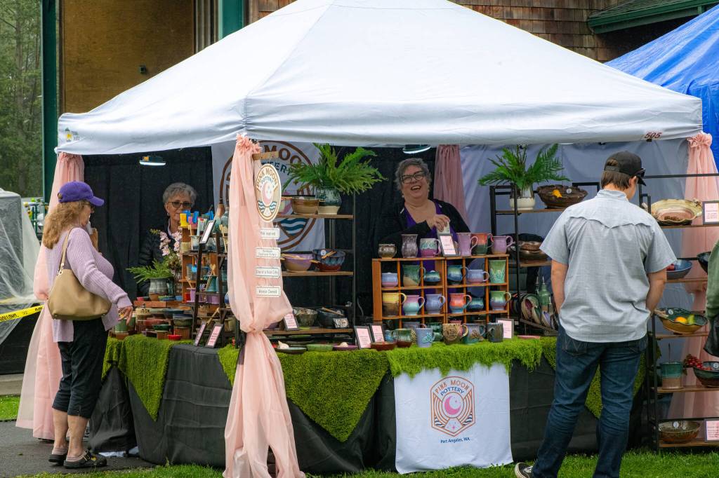 Sequim Gazette photo by Monica Berkseth/ Pink Moon Pottery, run by Marcie Connally, in center, has been making pottery for two years and was one of 200-plus vendors at Lavender Festival in the Park.