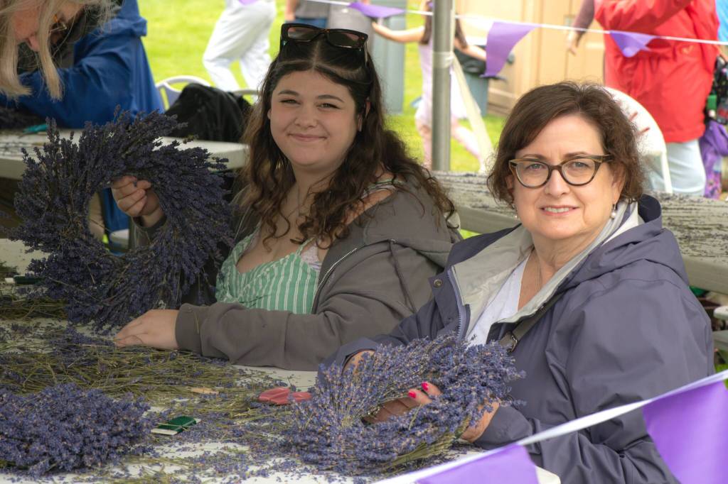 Sequim Gazette photo by Monica Berkseth/ Tracy Krawczyk and Lindsey Nielsen of Bellevue make wreaths at the Sequim Lavender Festival in the Parks activity tent.