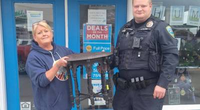 Photo courtesy Sarah Ketchum, Habitat for Humanity of Clallam County/ Sarah Ketchum, store manager of Sequim Habitat Boutique, accepts a table that was returned by Sequim Police Officer Abraham Blaylock on Friday, July 17. Sequim and Port Townsend Police Departments worked together to find the table and arrest a woman allegedly linked to the theft.