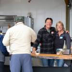 Sequim Gazette photo by Monica Berkseth/ Scott and Ginger Wierzbanowski, owners of the Olympic Bluffs Cidery and Lavender Farm, serve cider during the North Olympic Land Trusts Family Picnic on July 26. The couple has owned the property in Agnew for almost six years.