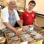 Photo courtesy Vera Felts/ Vera Felts with grandson Hudson Pelly look through collections at the Strait Stamp Show in the Guy Cole Event Center. The show returns Aug. 8.