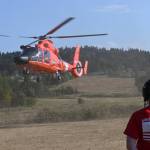Sequim Gazette file photo/ Madeline Patterson, a Sequim grad, looks on as a U.S. Coast Guard helicopter leaves the Unity of Effort venue in 2024. This year, five aircraft are scheduled to be at the event on Aug. 8, pending schedules and weather.