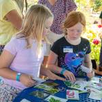 Sequim Gazette photos by Monica Berkseth/ Maisie Massey, left, and Ella Holland, both of Sequim, browse browse seed packets during a July 30 Boys & Girls Club field trip to the Community Organic Garden of Sequim.