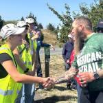 Sequim Gazette photo by Matthew Nash/ Patrick Smith of Florida greets Peninsula Trail Coalition trail ambassadors, including Ashton Reichner, on Aug. 3.