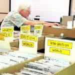 Sequim Gazette photo by Matthew Nash/ Jim Kloetzel of Port Ludlow looks for an assortment of advertisements, novelty postcards, and leather postcards at the Strait Stamp Show. Kloetzel moved to the peninsula 15 years ago and joined the club around then, he said.