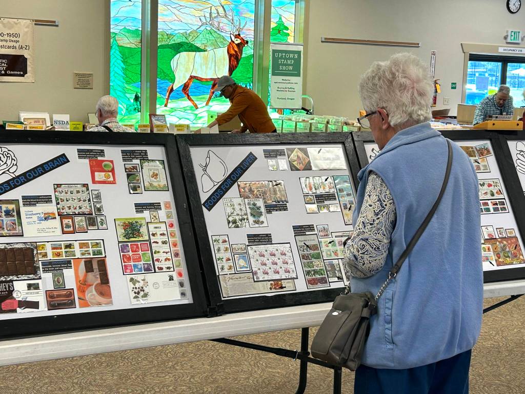 Sequim Gazette photos by Matthew Nash 
June Geovin of Rochester admires exhibits from Strait Stamp Show club members. She traveled with her husband Dennis, an avid stamp collector, to the Sequim show on Aug. 8.