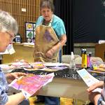 Mary Lou Giacomelli demonstrates gel plate printing on fabric at the Sunbonnet Sue Quilt Clubs show on Aug. 7 as Noni Farris, left, and Mary Alden, right, both of Sequim, admire her technique.