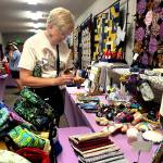 Sequim Gazette photo by Matthew Nash/ Teresa Frank of Sequim looks through items in the Quilters Boutique during the Sunbonnet Sue Quilt Clubs show. Frank, a national embroiderer judge, said she was devastated when the club didnt have their show last year. Folks here do such incredible work, she said.