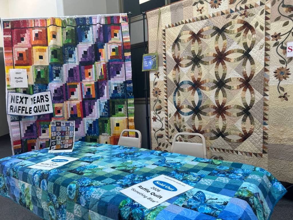 Sequim Gazette photo by Matthew Nash/ Next years Raffle Quilt, left, was on display next to this years quilt, which sold out of tickets on Aug. 7 at the Sunbonnet Sue Quilt Clubs annual show. Tickets support the nonprofit clubs efforts.