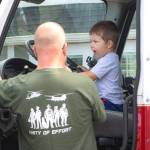 Sequim Gazette photo by Monica Berkseth/ Two-year-old Noah Pedde sits in a fire trucks drivers seat during Unity of Effort as his dad Brian of Snohomish watches.